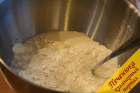 2) Затем заранее просеянную пшеничную муку всыплем в глубокую емкость, в которой мы сможем замесить тесто для булочек. В центр муки вольем  растворенные дрожжи в воде. 