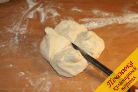 5) Выкладываем готовое тесто на стол. Разрезаем его крестообразно. Присыпаем тесто мукой.