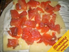 2) Порезать кусочками красную рыбу. Выложить ее на сыр так, чтобы каждый кусочек рыбы был как можно ближе к соседнему.