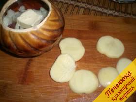 4) Почистить картофель, порезать его колечками не очень тонкими. Картофелем выкладывается следующий слой в горшочке. На него также кладется кусочек масла сливочного.