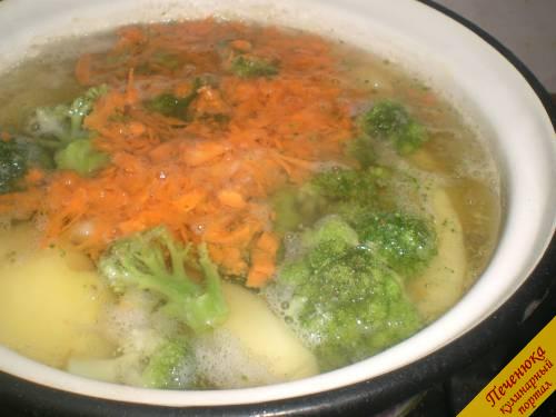 4) При помощи средней терки измельчить морковку. Отправить овощ в кастрюлю следом за брокколи. Варить, пока все овощи не станут мягкими. 
