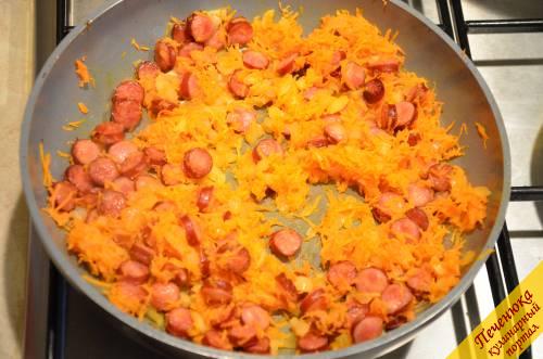 5) Лук мелко порезать, а морковь натереть на мелкой терке. Когда колбаски подрумянятся, отправить овощи на сковороду. Слегка их обжарить.