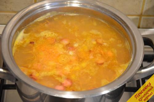 6) Когда картофель и горох будут готовы, отправить в кастрюлю обжаренные колбаски с луком и морковью. Проварить еще в течение 5 минут.