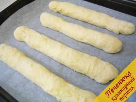 6) Из каждой части формуем длинный тонкий багет. Если тесто будет липнуть к пальцам, погрузите ладошки в пакет с мукой и после этого приступайте к формированию багетов. 